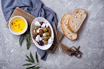 Wall Mural - Bowl of delicious olives with Feta cheese in oil and bread