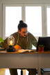 © Carlos - Vertical shot of male studying and taking notes with laptop and books