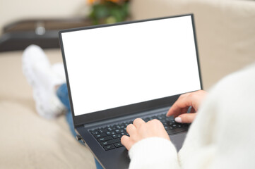 Poster - Laptop with blank white screen. woman working and typing on laptop computer with blank screen while lying on a sofa at home. mockup laptop