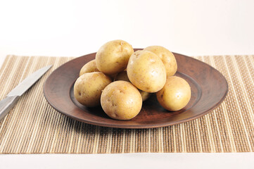 Wall Mural - young potatoes in the peel on a clay plate