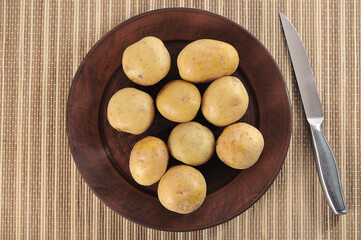 Wall Mural - young potatoes in the peel on a clay plate