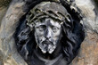 A sculpture of Jesus Christ in a crown of thorns in a Catholic cemetery. Close-up of the face.