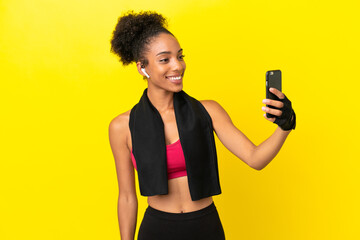 Poster - Young African sport woman isolated on yellow background making a selfie