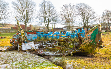 Abandoned wooden ship wreck on frost covered grass on the Dee estuary, Scotland