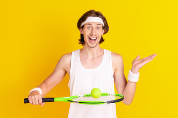 Sticker - Portrait of attractive skilled cheerful guy playing tennis holding ball on racket isolated over bright yellow color background