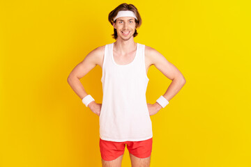 Sticker - Portrait of attractive cheerful sportive guy hands on hips isolated over bright yellow color background