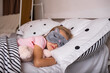 a little girl in a sleep mask sleeps in bed with a stuffed toy