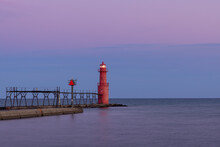 A Red Breakwater Lighthouse Along Lake Michigan Illuminated At Night