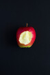 Top view of bitten apple on a black background. Copy space. Natural food.