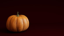 Pumpkin On A Deep Plum Red Colored Background. Autumn Themed Image With Copy-space.