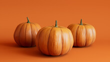 Three Pumpkins On A Orange Colored Background. Autumn Themed Image.