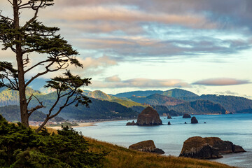 dramatic sunset in Cannon beach with the Haystack Rock on the background viewed from Ecola State Park in Oregon.