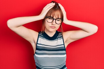 Sticker - Redhead young woman wearing casual clothes and glasses suffering from headache desperate and stressed because pain and migraine. hands on head.