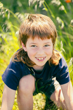 Boy With Mullet In Pretty Natural Setting With Wildflowers And Long Grass