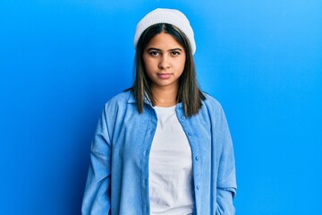 Poster - Young latin woman wearing cute wool cap skeptic and nervous, frowning upset because of problem. negative person.