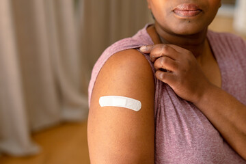 African american senior woman showing plaster after vaccination