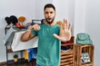 © Krakenimages.com - Young handsome man with beard holding shopping bags at retail shop doing stop gesture with hands palms, angry and frustration expression
