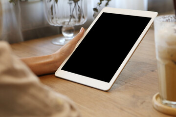 Businesswoman using mockup tablet on wooden desk