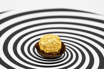 Wall Mural - a candy wrapped in gold foil on Hypnosis visualisation conept endless spiral background