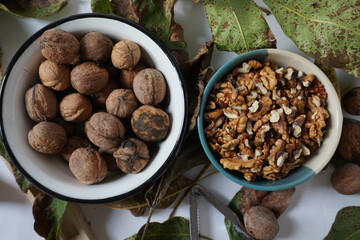 Top view of two bowls with whole and cracked walnuts             