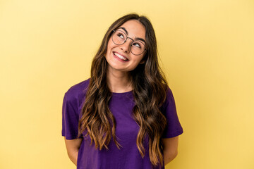 Young caucasian woman isolated on yellow background relaxed and happy laughing, neck stretched showing teeth.