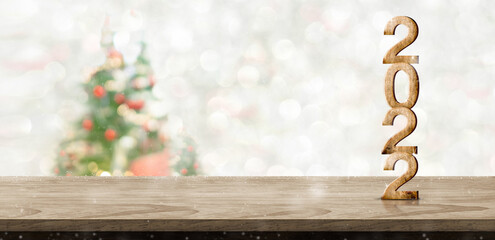 Leinwandbilder - Happy new year and merry Christmas  2022 number wood on table at blur bokeh xmas tree decor with string light background,Winter  greeting card for winter seasonal
