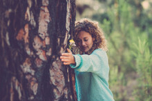 Young Woman Hugging Tree With Eyes Closed In Forest. Beautiful Caucasian Woman Embracing Tree With Love And Care. Thoughtful Woman Touching Tree Bark In Forest