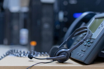 Wall Mural - close up soft focus on headset with telephone devices at in datacenter operation room  for support and customer service support concept	