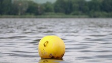 A Yellow Buoy Is Floats On A Surface Of Water In A Lake, Slow Motion.