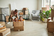 Wide angle portrait of two boys playing in big cardboard box while family moving to new house, copy space