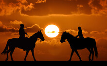Silhouette Of Two Riders On Sunset