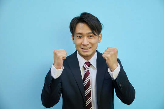 応援するスーツ姿の日本人男性