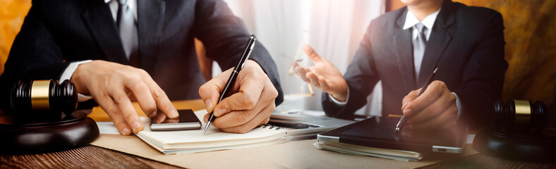 Business and lawyers discussing contract papers with brass scale on desk in office. Law, legal services, advice, justice and law concept