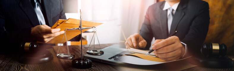 Business and lawyers discussing contract papers with brass scale on desk in office. Law, legal services, advice, justice and law concept