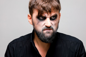 Wall Mural - Portrait of a man with a beard and a menacing look with undead-style makeup on All Saints' Day on October 31