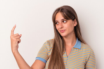 Wall Mural - Young caucasian woman isolated on white background pointing with finger at you as if inviting come closer.