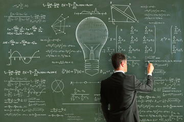 Wall Mural - Attractive young european businessman drawing abstract lamp sketch with mathematical formulas on chalkboard/blackboard wall background. Intelligence, idea, solution, science and innovation concept.