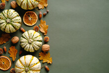 Happy Thanksgiving Concept. Autumn Composition With Ripe Pumpkins, Fallen Leaves, Dry Oranges On Rustic Green Table. Flat Lay, Top View, Copy Space.