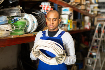 Confident latin american handyman man choosing materials for overhauls in building materials store