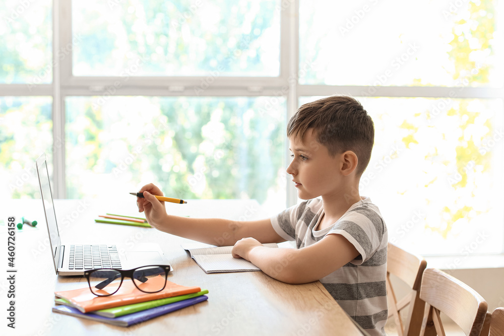 Little boy doing lessons online at home