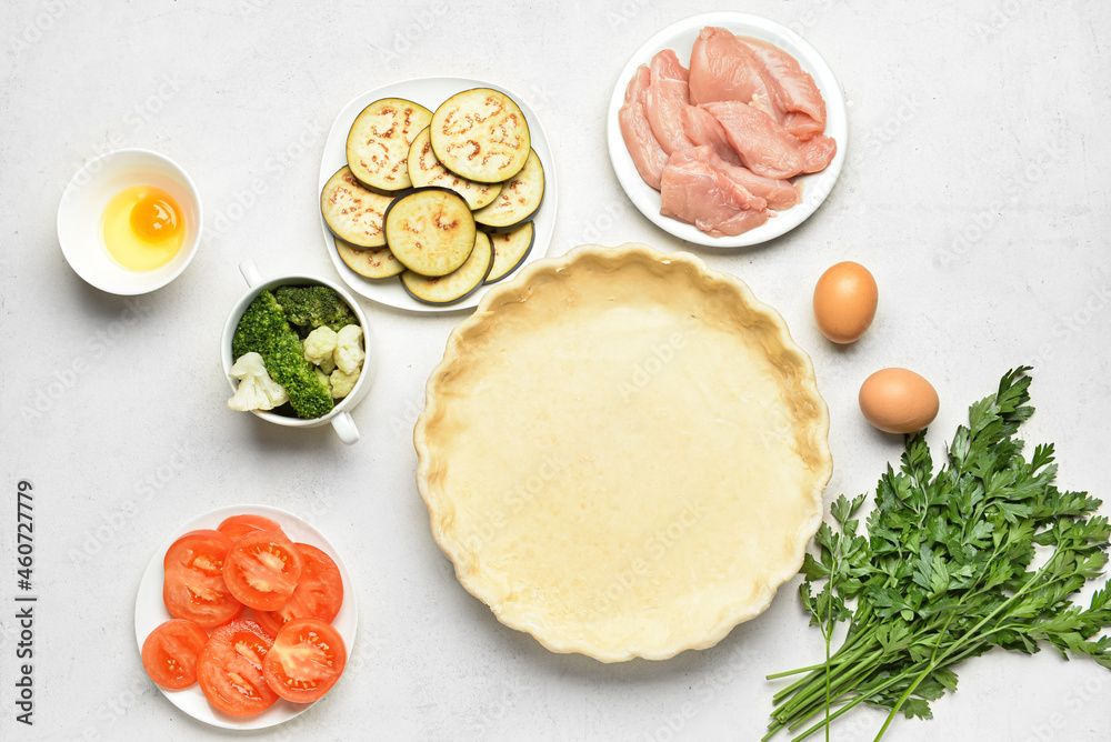 Raw dough and ingredients on white background