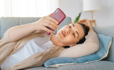 Sticker - woman is using a phone sitting on a sofa