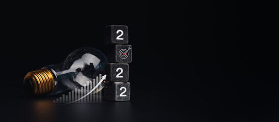 Poster - 2022 Happy New year banner with goal target and success concept. The 2022 numbers on black dice stack, business growth chart, light bulb on dark background with copy space, modern and minimal style.