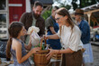 © Halfpoint - Little girl with her mother buying organic vegetables outdoors at community farmers market.