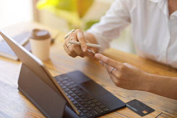 Close up Adult woman holding credit card for online shopping at home