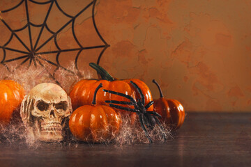 Halloween party set up props. Three skeletons having a spooky party with pumpkin and spider and a lollipop. Dia de los Muertos and Halloween. Dark themed copy space. trick or treat