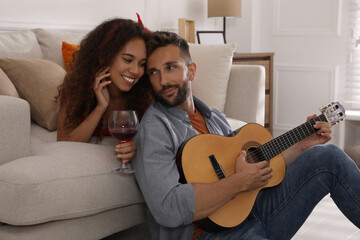 Wall Mural - Lovely couple with guitar spending time together at home