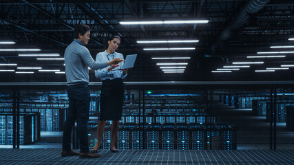 Leinwandbilder - Data Center Female System Administrator and Male IT Specialist Talk, Use Laptop Computer. Information Technology Engineers work on Cyber Security Network Protection in Cloud Computing Server Farm.