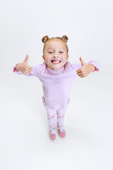 high angle view of beautiful little girl with hair buns on my head in modern stylish outfit isolated
