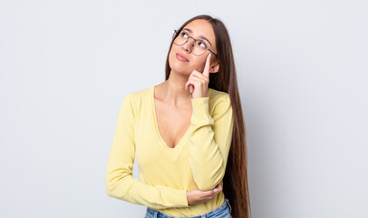 Poster - hispanic pretty woman with a concentrated look, wondering with a doubtful expression, looking up and to the side